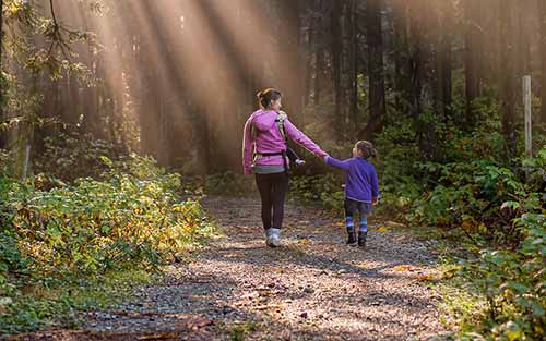 Adult and child walking a path together